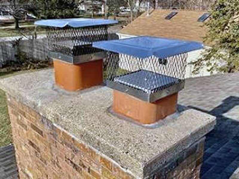 top-sealing damper caps fitted over the flues on a chimney in Woodbridge, NJ